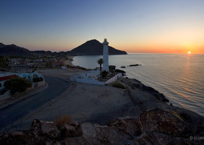 Lighthouse sunrise on a calm sea