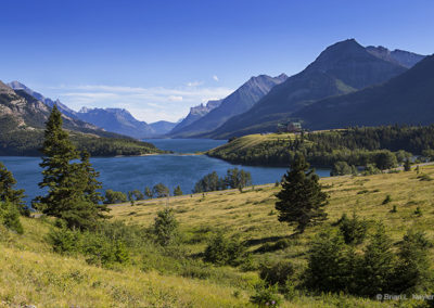 Grassy vista of lake and mountains