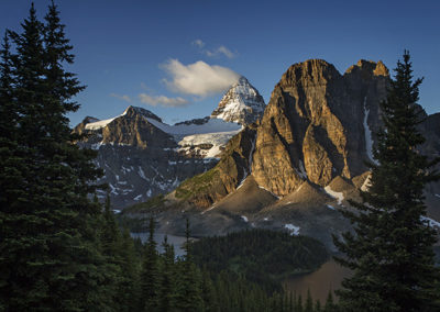 Early light on mountain face and forest lakes