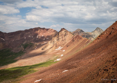 Sun warms the mountain pass highlights in red hues