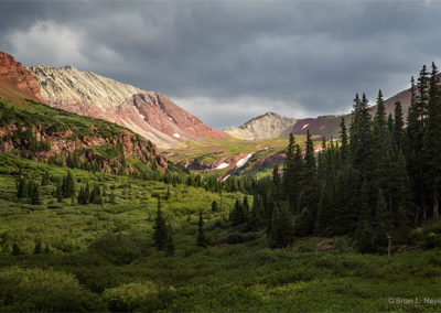 Threatening clouds build up over the bare mountain pass.