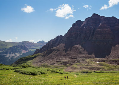 Lofty mountain peaks tower over approaching hikers