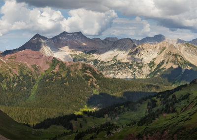 accumulating clouds loom heavily over mountains and lakes